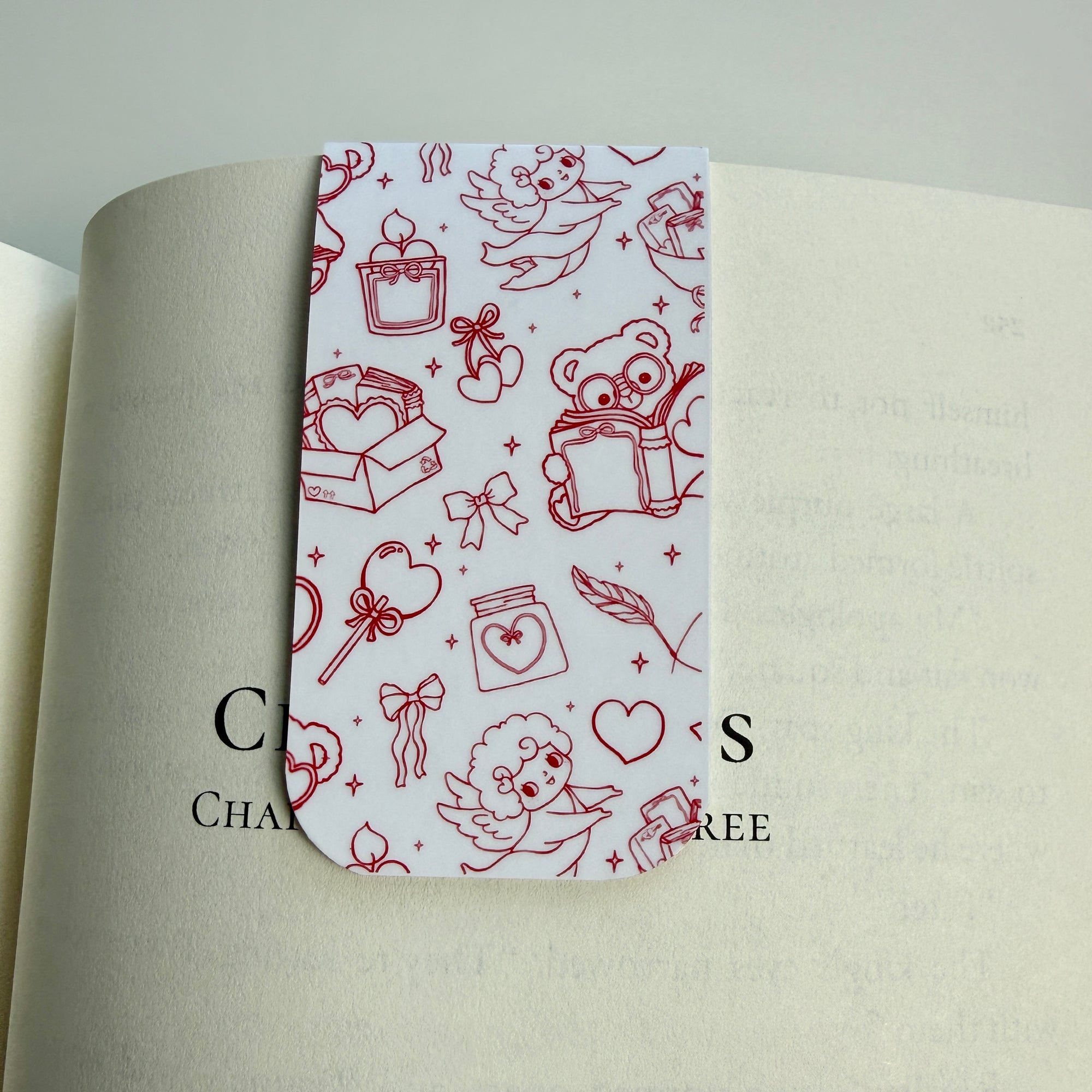 white magnetic bookmark with red doodles on a book page
