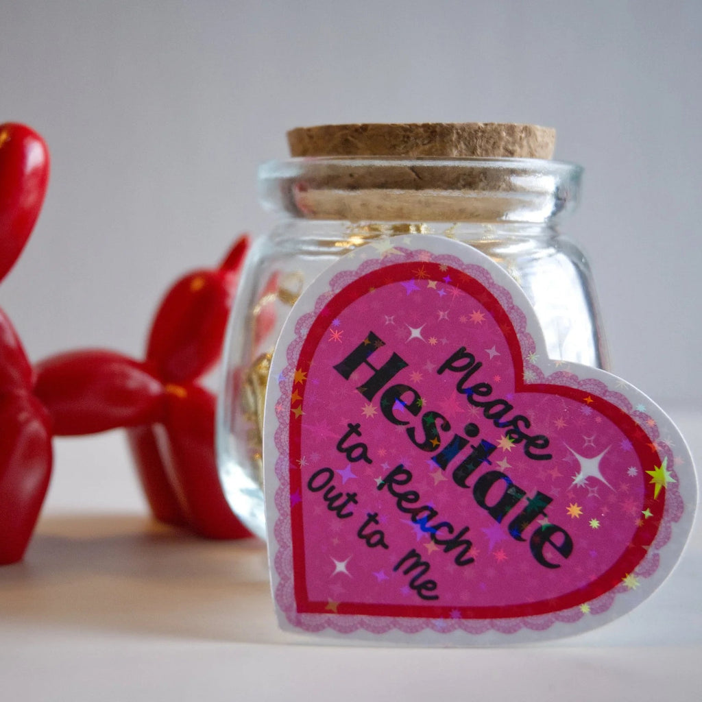 Glass jar with heart-shaped label and red balloon dog on a light background