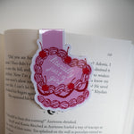 Book with a decorative bookmark featuring red cherries and text on a white background