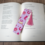 Pink cowgirl bookmark with tassel on an open book