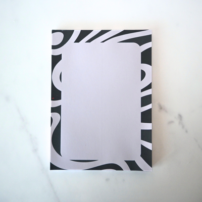 Notebook with black and white abstract design on a marble surface