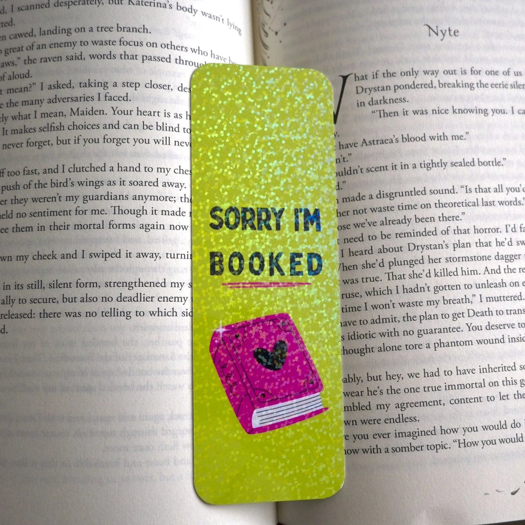 Green bookmark with 'Sorry I'm Booked' text on a book page