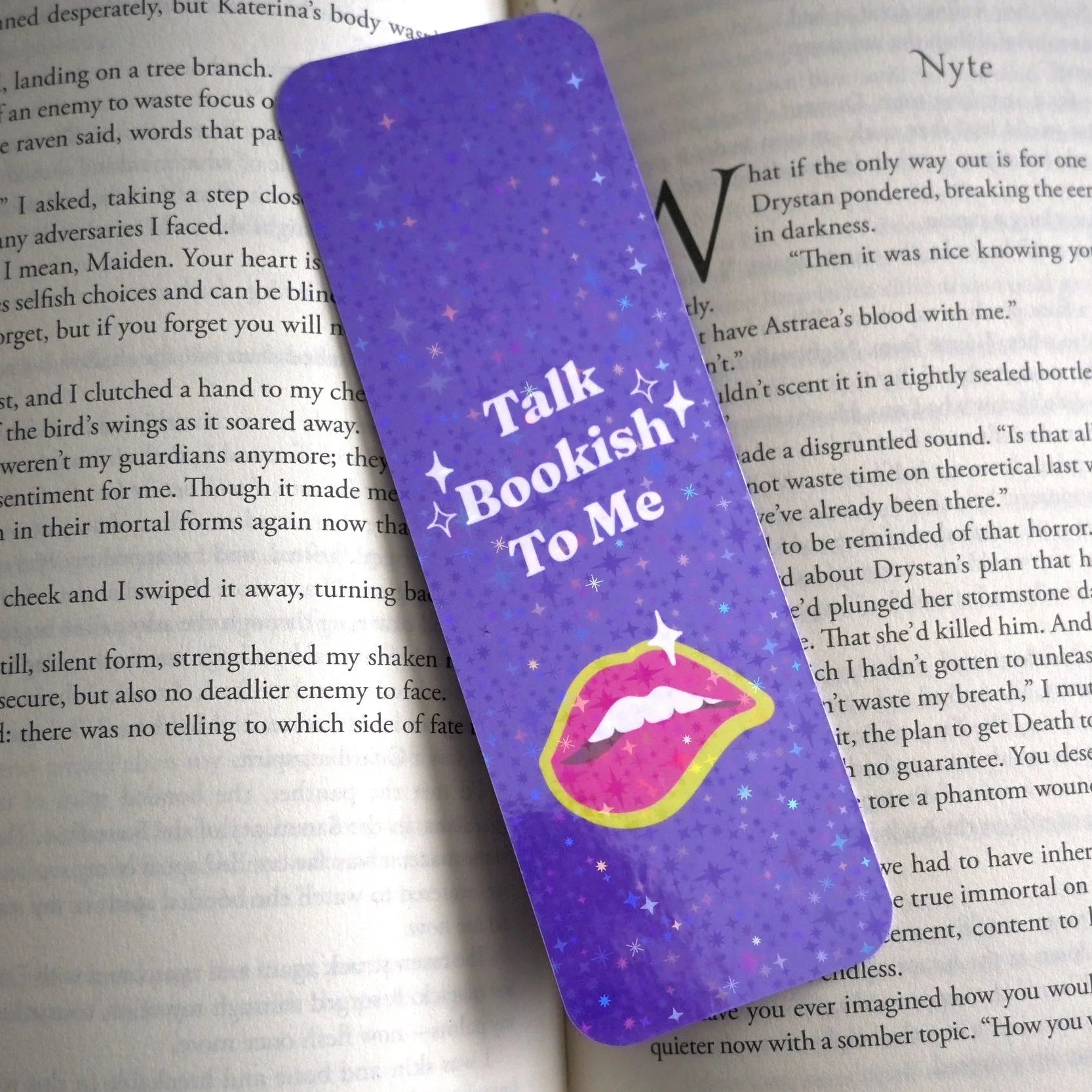 Purple bookmark with 'Talk Bookish To Me' text on a book page