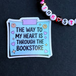 Sticker with text 'The way to my heart is through the bookstore' on a dark background