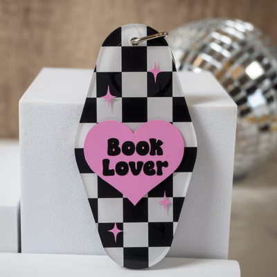 Checkered keychain with pink heart and 'Book Lover' text on a white surface.