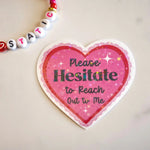 Heart-shaped sign with 'Please Hesitate to Reach Out to Me' text on a light background
