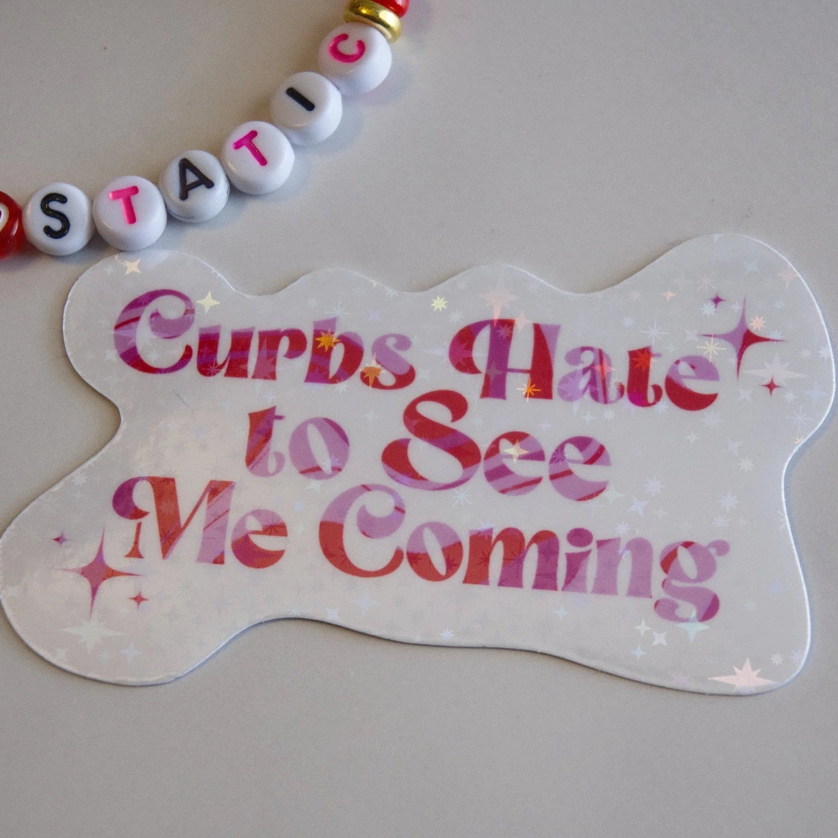 Dog tag with 'Curbs Hate to See Me Coming' text on a plain background