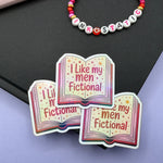 Colorful book-shaped sticker with text 'I Like my men Fictional' on a black and purple background.
