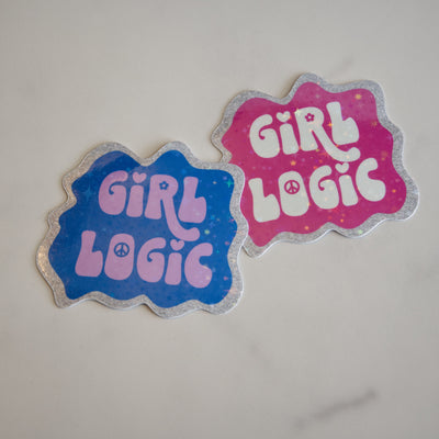 Two 'Girl Logic' stickers, one blue and one pink, on a light gray background.