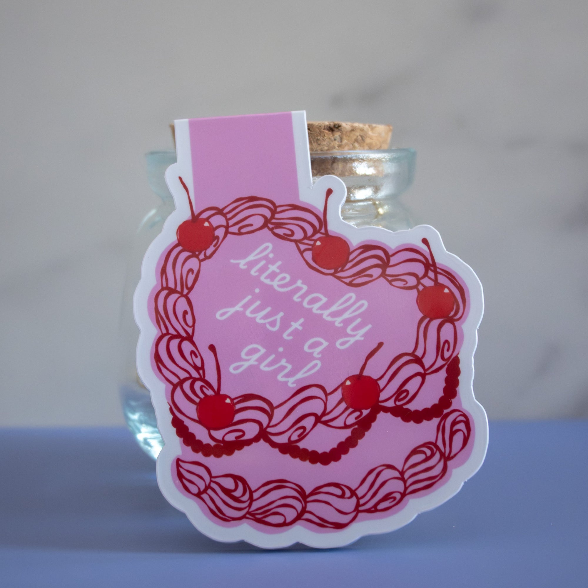 Small glass jar behind pink magnetic bookmark