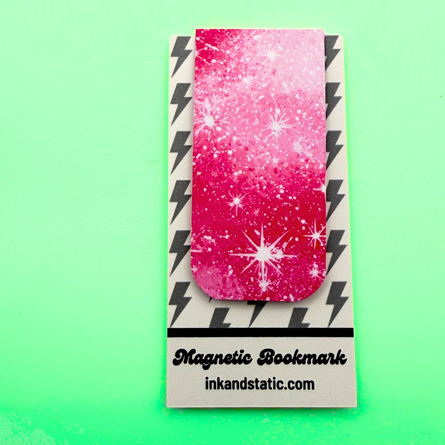 Magnetic bookmark with pink and white design on a green background