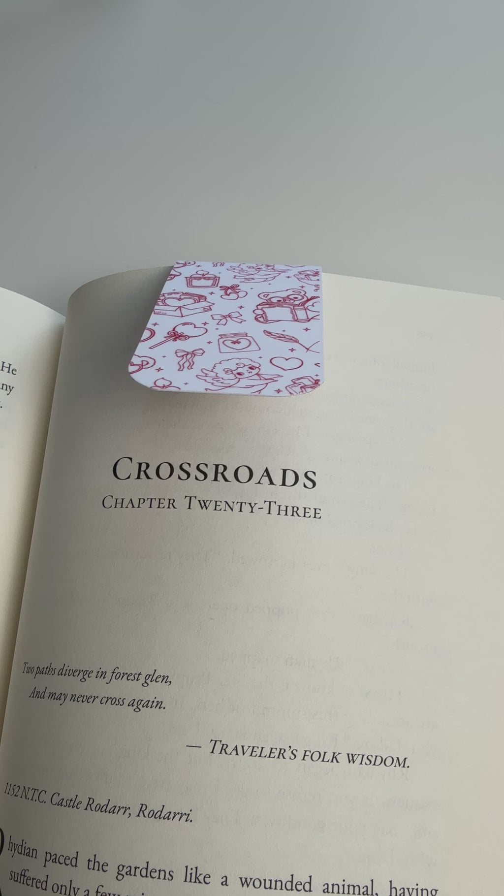 white magnetic bookmark with red hand drawn doodles snapping over book page