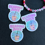 Three 'Reading Juice' stickers with a drink graphic on a dark background