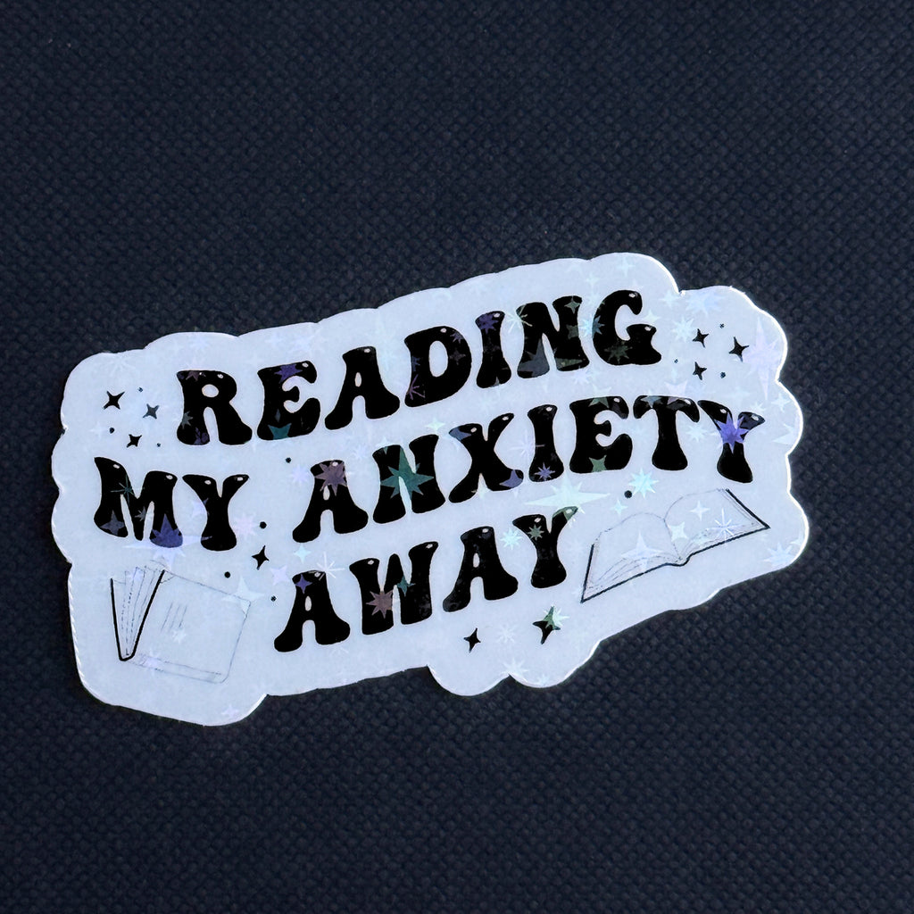 Sticker with 'Reading my anxiety away' text on a dark background