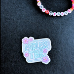 Sticker with 'Endless TBR' text on a dark fabric background