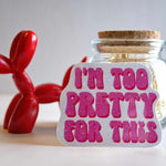 Glass jar with cork lid and 'I'm too pretty for this' sticker, next to a red balloon dog on a light background