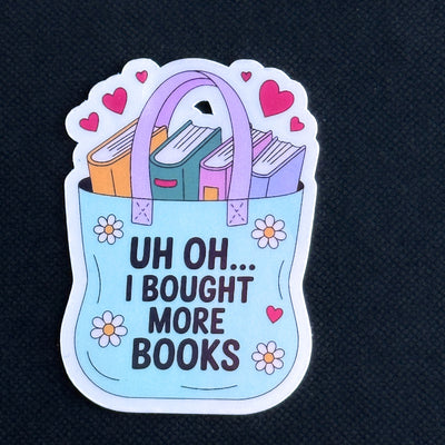 Sticker with a tote bag full of books and text 'Uh oh... I bought more books' on a black background