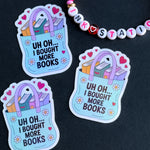 Three stickers with a book bag design and text 'Uh oh... I bought more books' on a dark background.